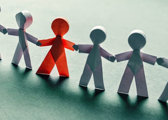 Diverse paper people chain on blue surface, inclusion, unity, teamwork. symbolize equal rights, community support, harmonious multicultural society. Concept solidarity, partnership, togetherness